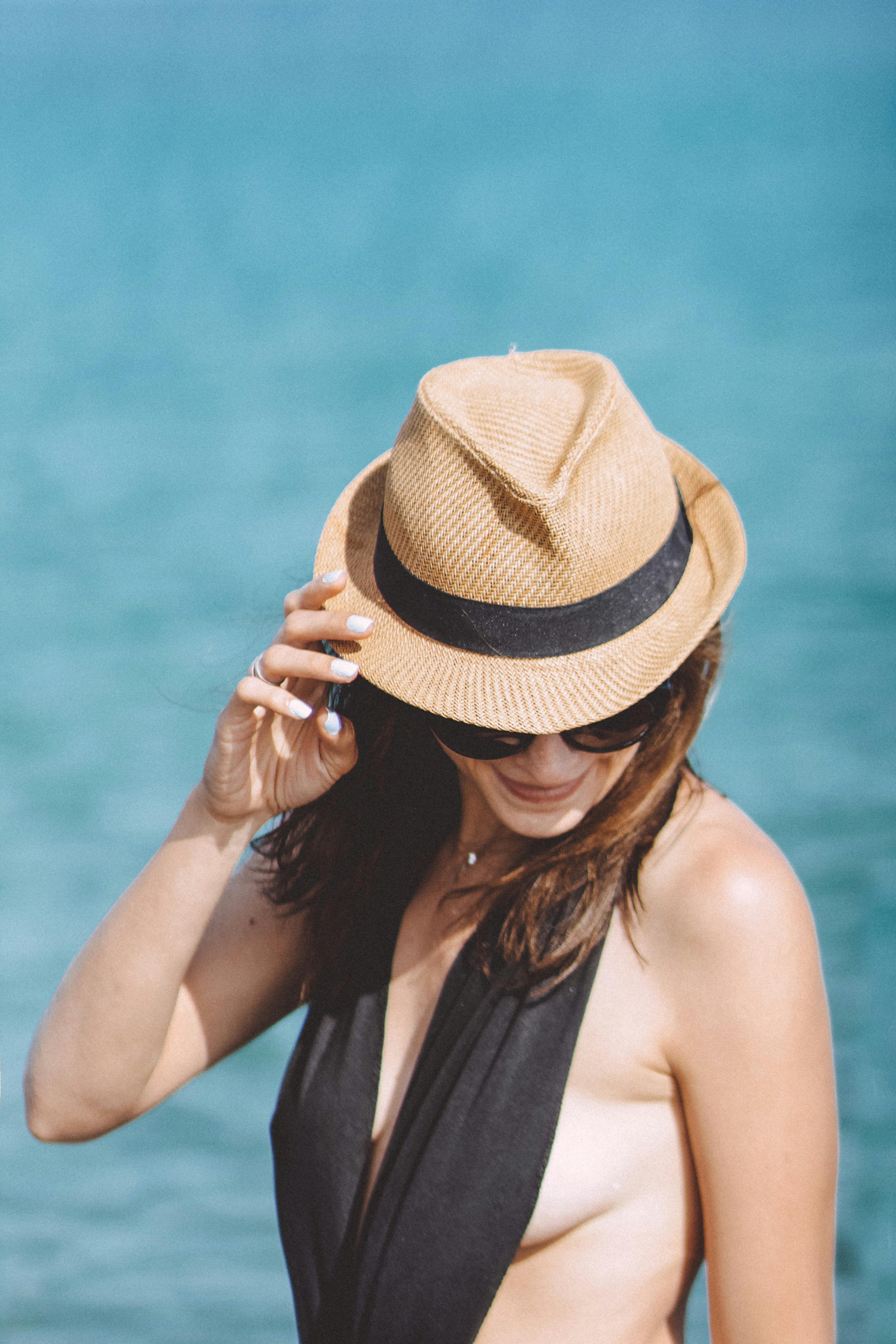 woman in black tank top wearing brown fedora hat